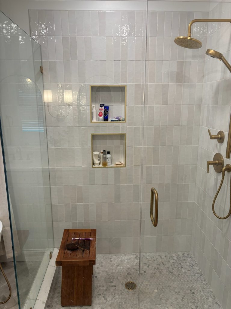 Shower with penny tile floor and teak bench