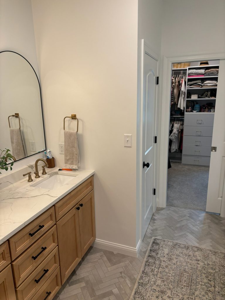 Vanity and towel ring with closet doorway beyond