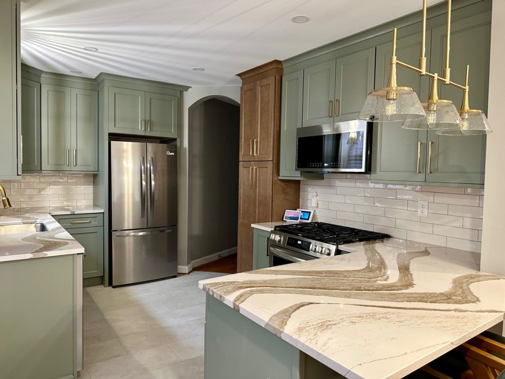 Green cabinetry with gas range and stained pantry tower