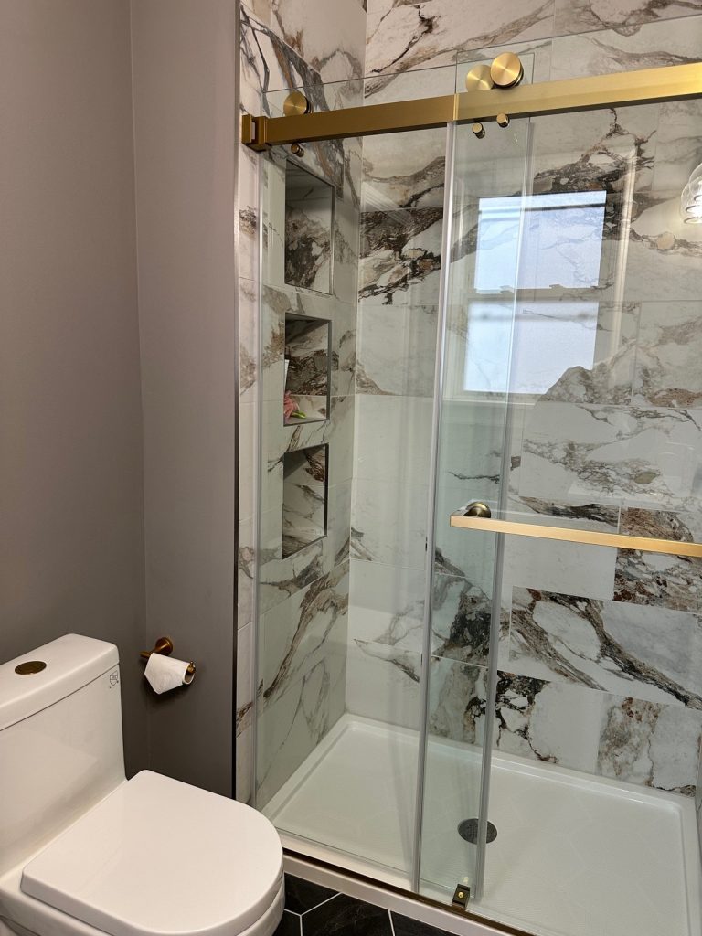 Shower with stacked niches and brass hardware