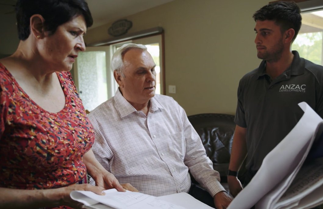 Anzac Developments team reviewing addition plans with homeowners