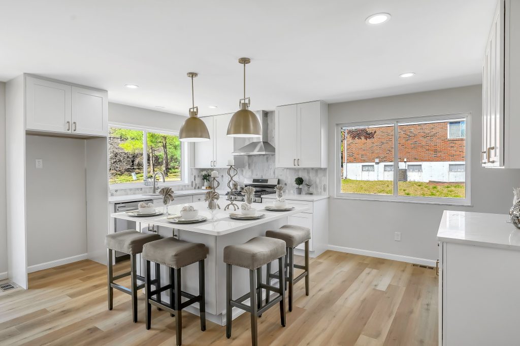 Kitchen with white island, stools and pendant lights