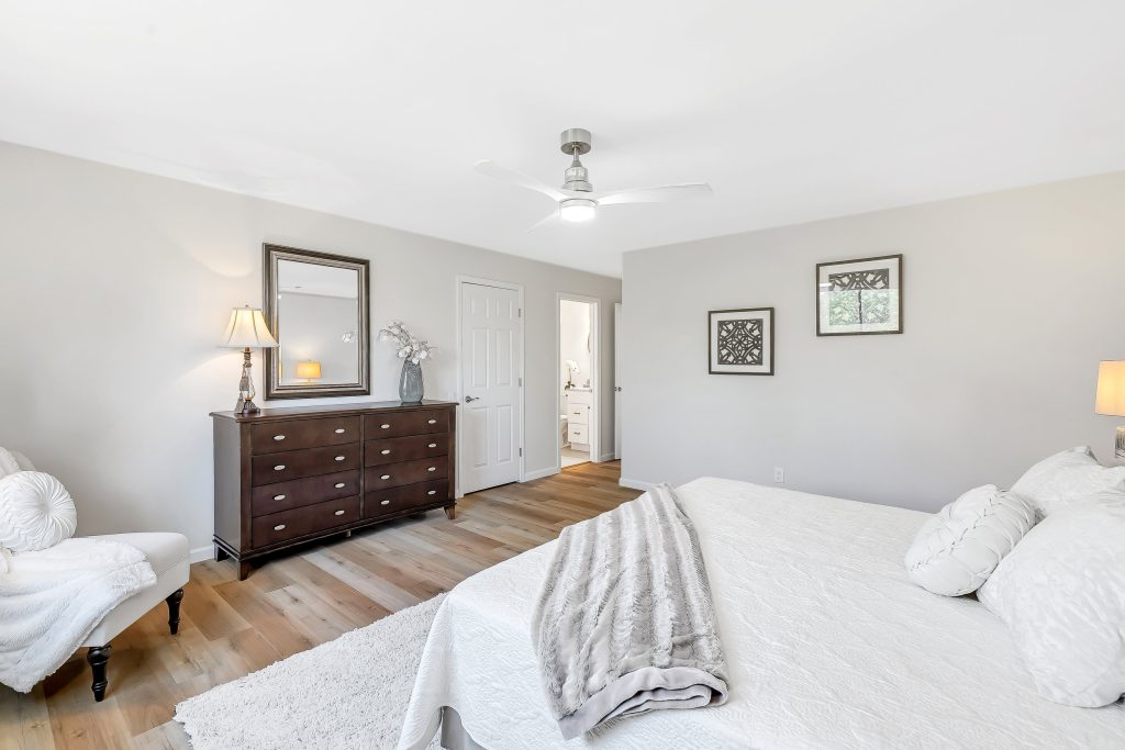 Bedroom with dresser, bed and doorway beyond