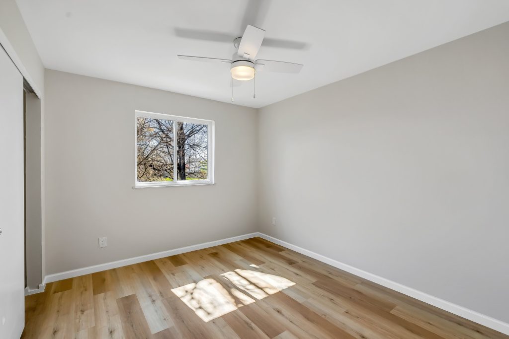 Empty bedroom with ceiling fan and window
