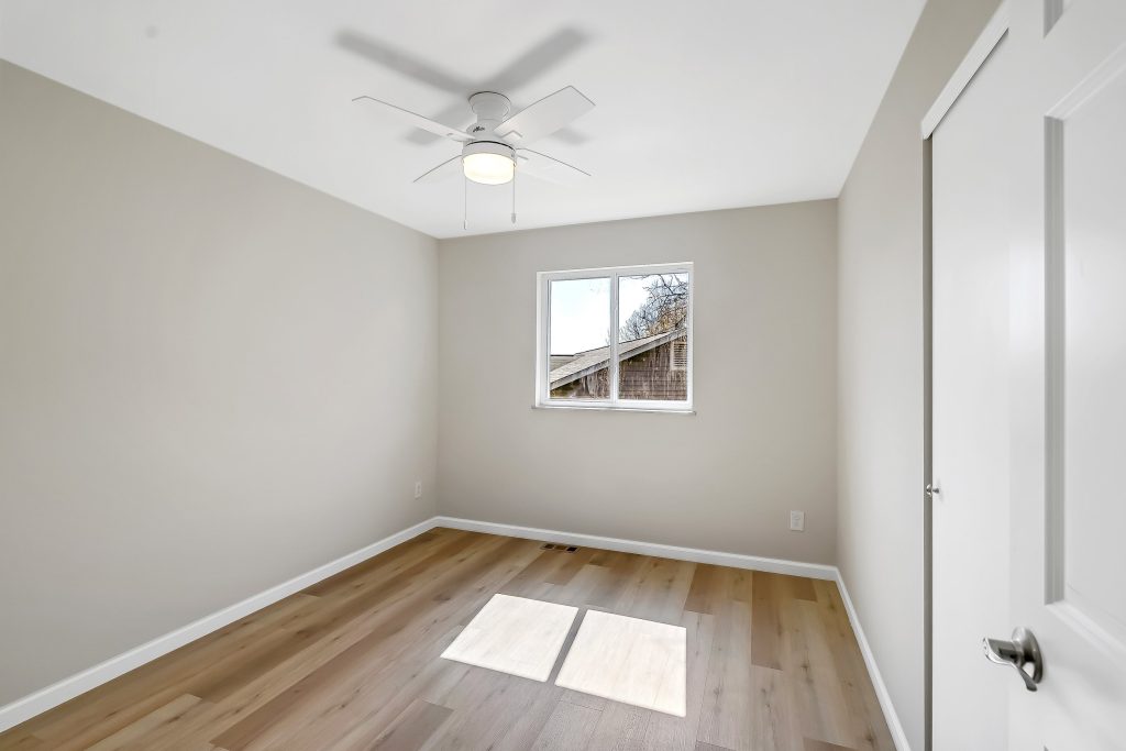 Empty bedroom with ceiling fan and door