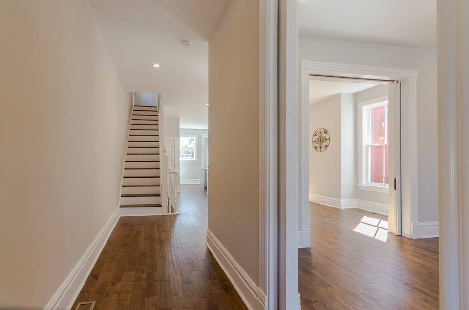 Hallway with refinished hardwood floors leading to the staircase