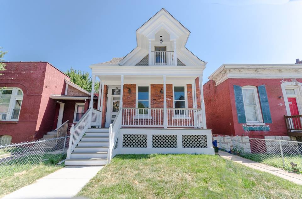 Restored brick house front elevation with white covered porch