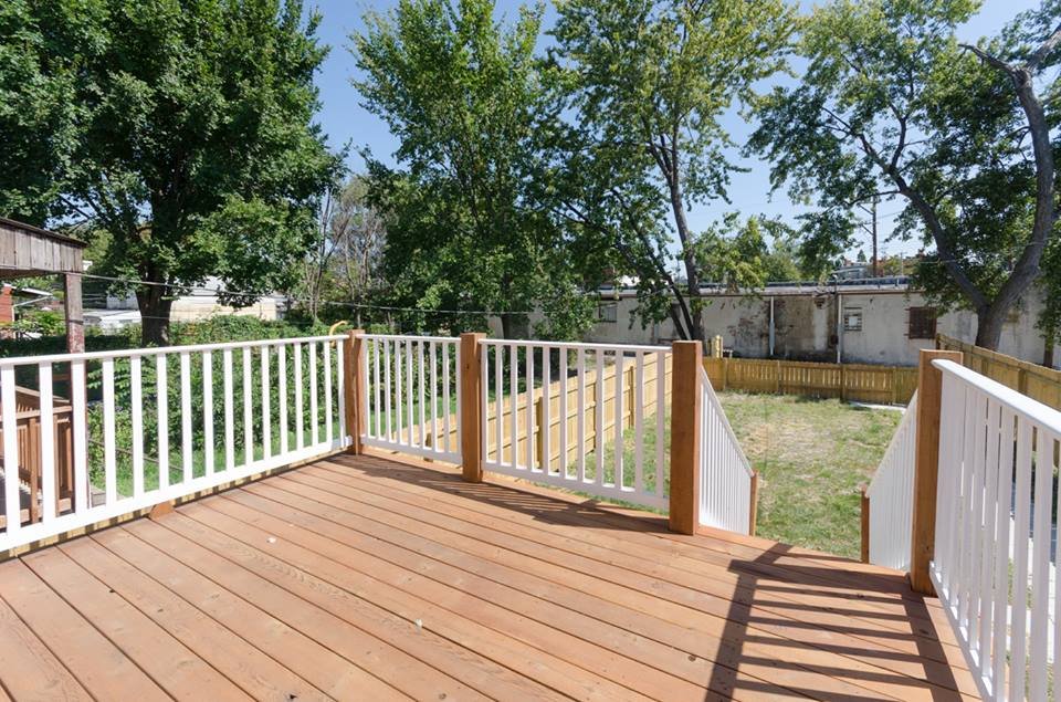New wood deck with white railings at the rear of the house