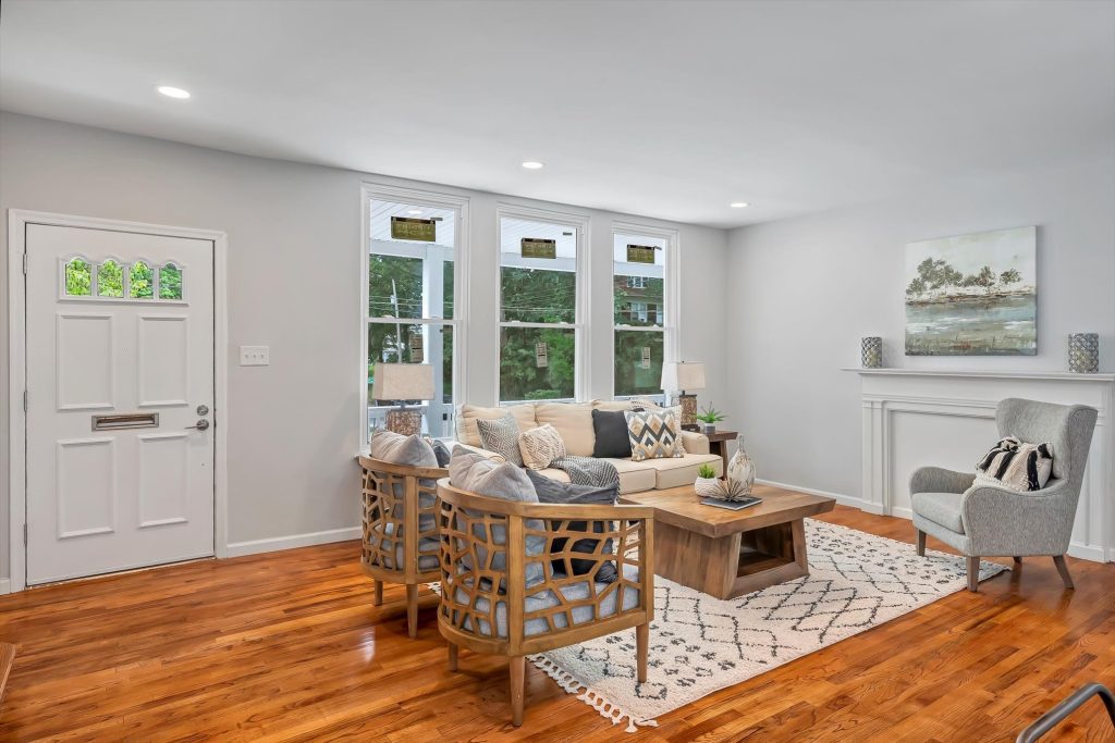 Living room with front door, bay windows and armchairs