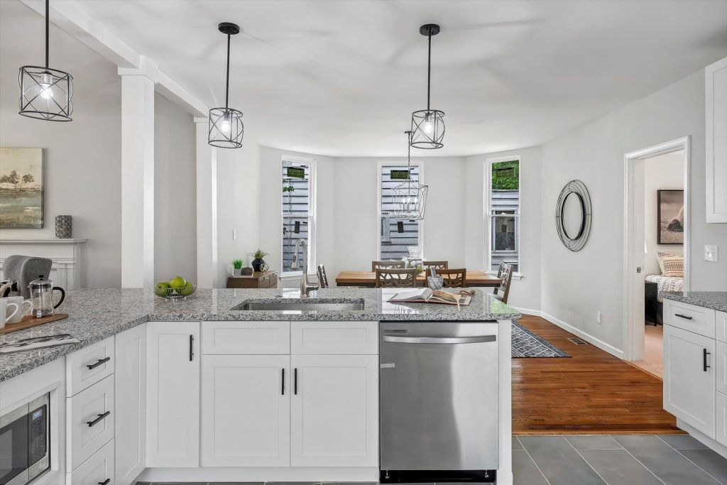 Kitchen with white cabinets, stainless dishwasher and peninsula