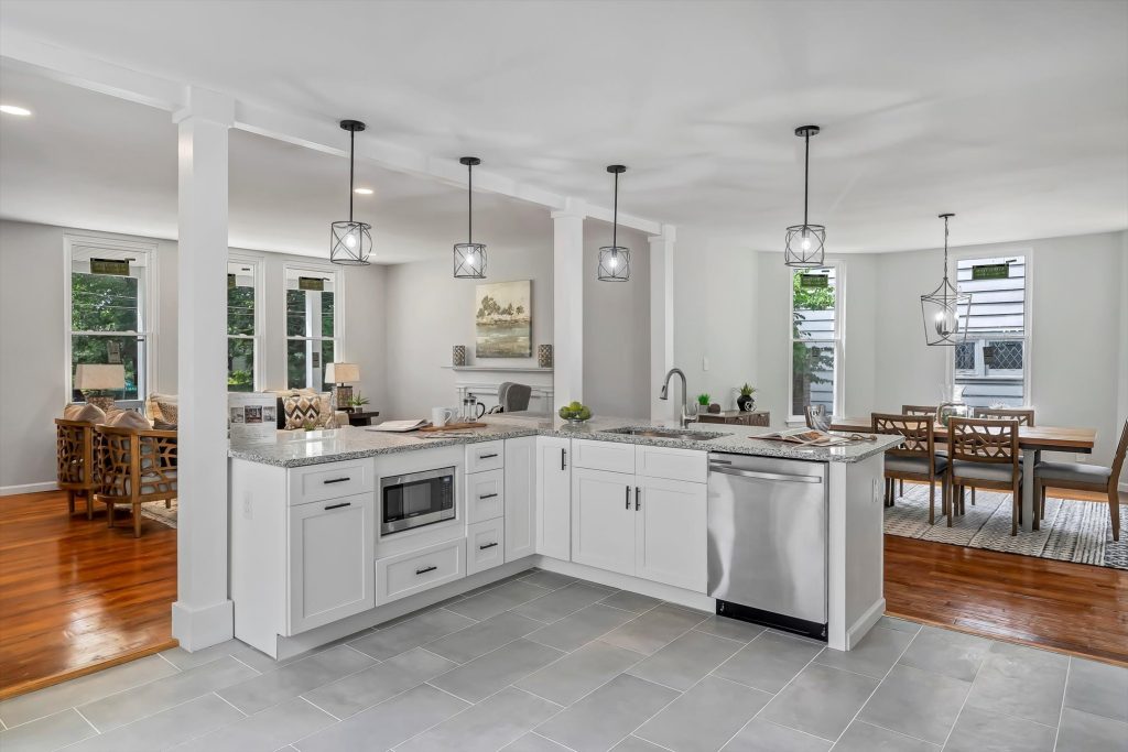Kitchen with white cabinets, microwave and gray tile floor