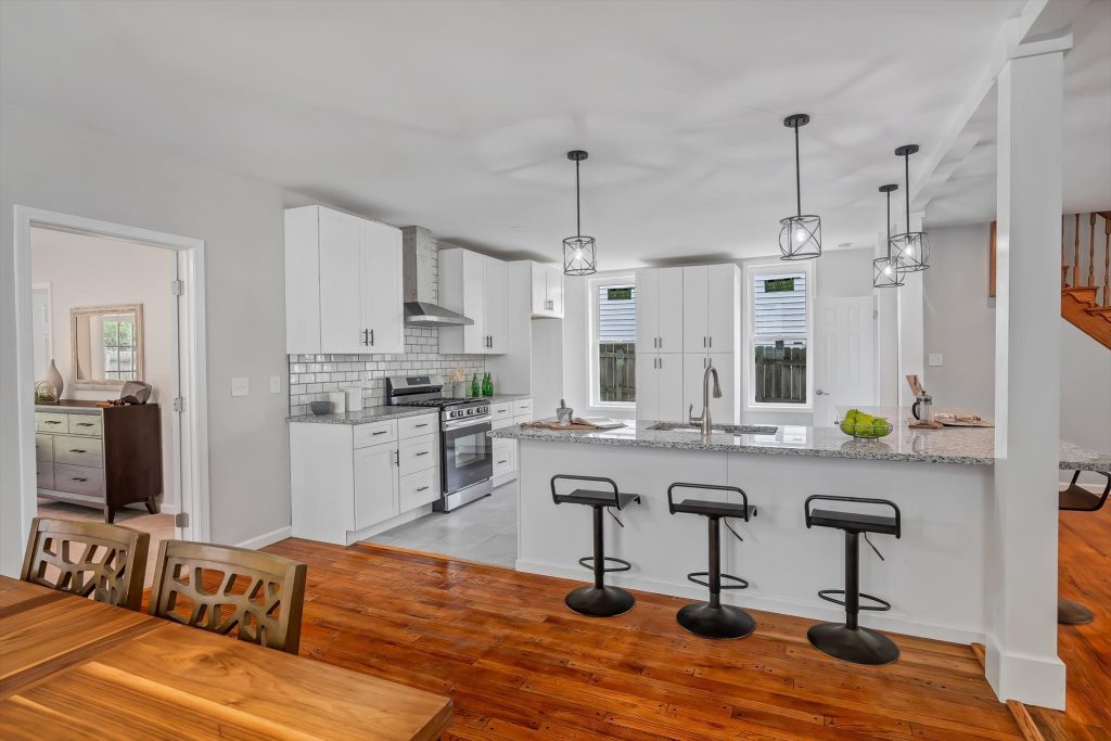 Kitchen with island, stools and stainless range hood