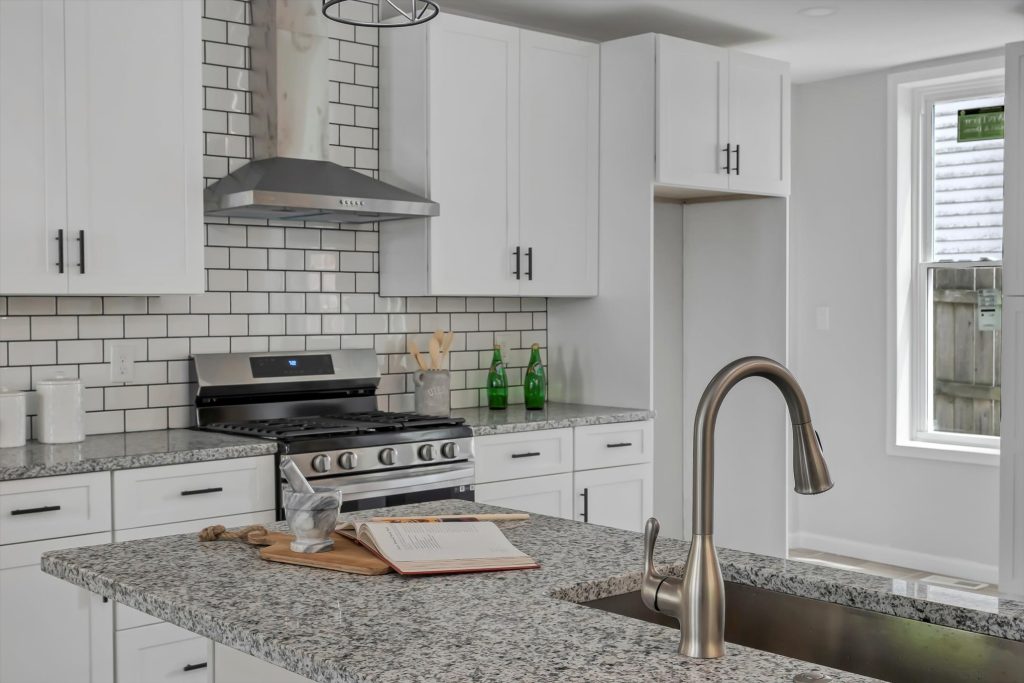 Kitchen countertop with gooseneck faucet and subway tile backsplash