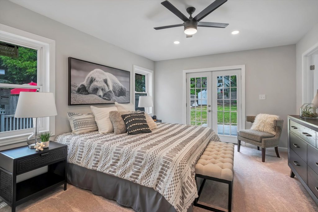 Primary bedroom with ceiling fan and French doors