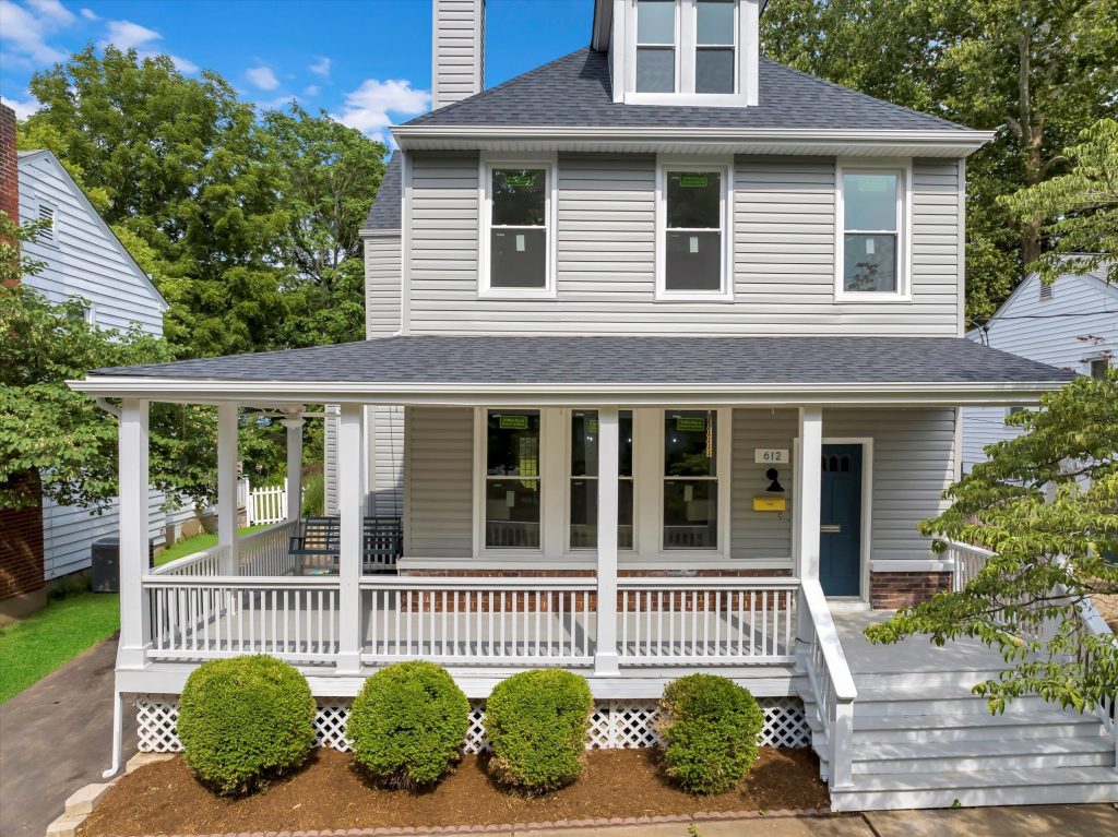 Front elevation with covered porch and clipped shrubs