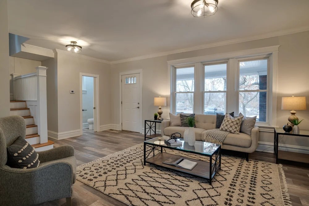 Open living room with neutral furnishings in a design-build home
