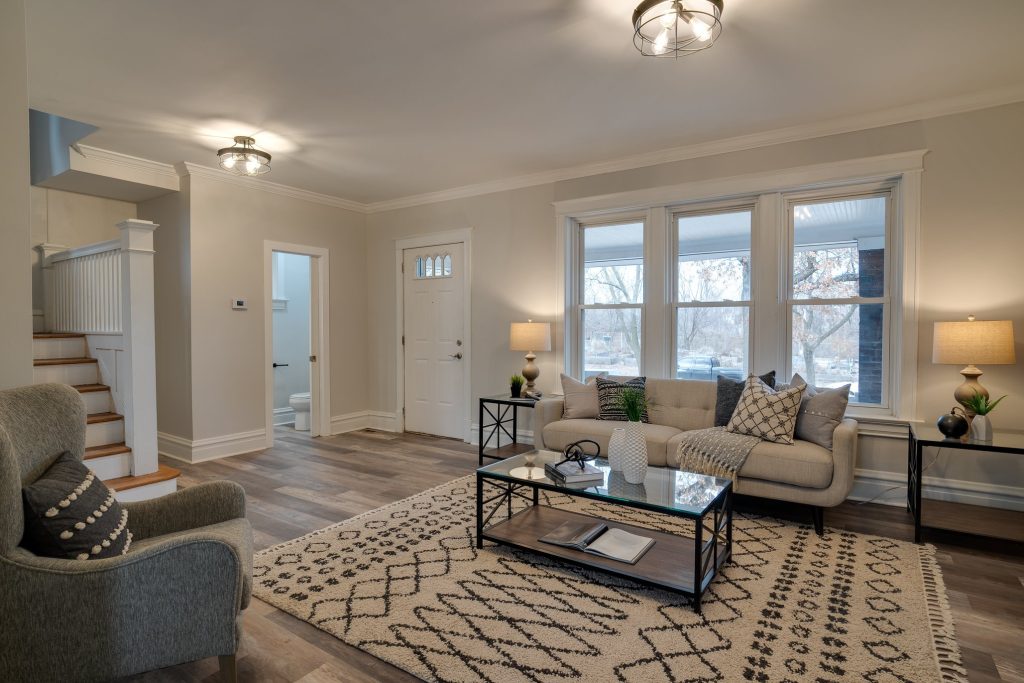 Living room with staircase, front door and patterned rug