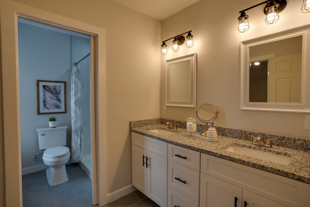 Bathroom with double granite vanity and industrial light fittings