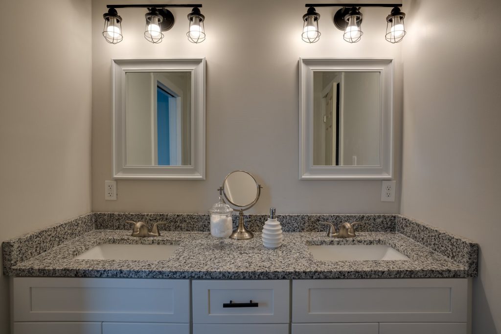 Double vanity with granite top and two framed mirrors
