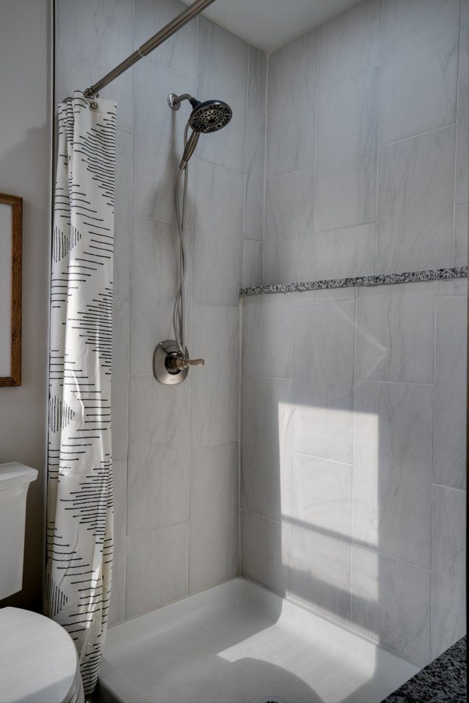 Tiled walk-in shower with mosaic border