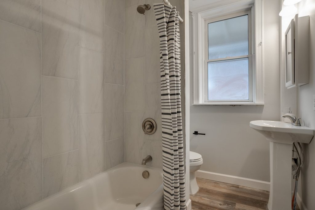 Tub and shower with tiled surround and pedestal basin