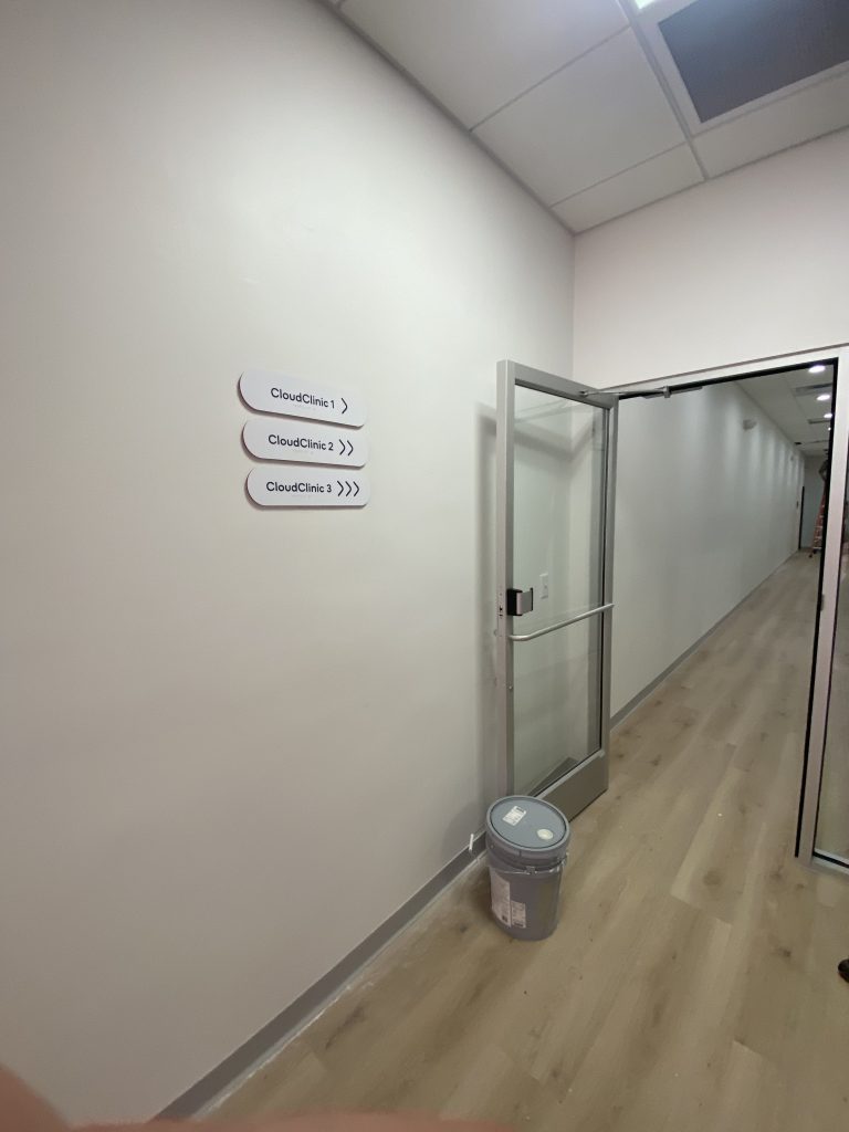 Clinic corridor with glass door and wayfinding signage