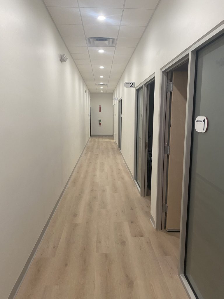 Clinic corridor with glazed consulting room doors