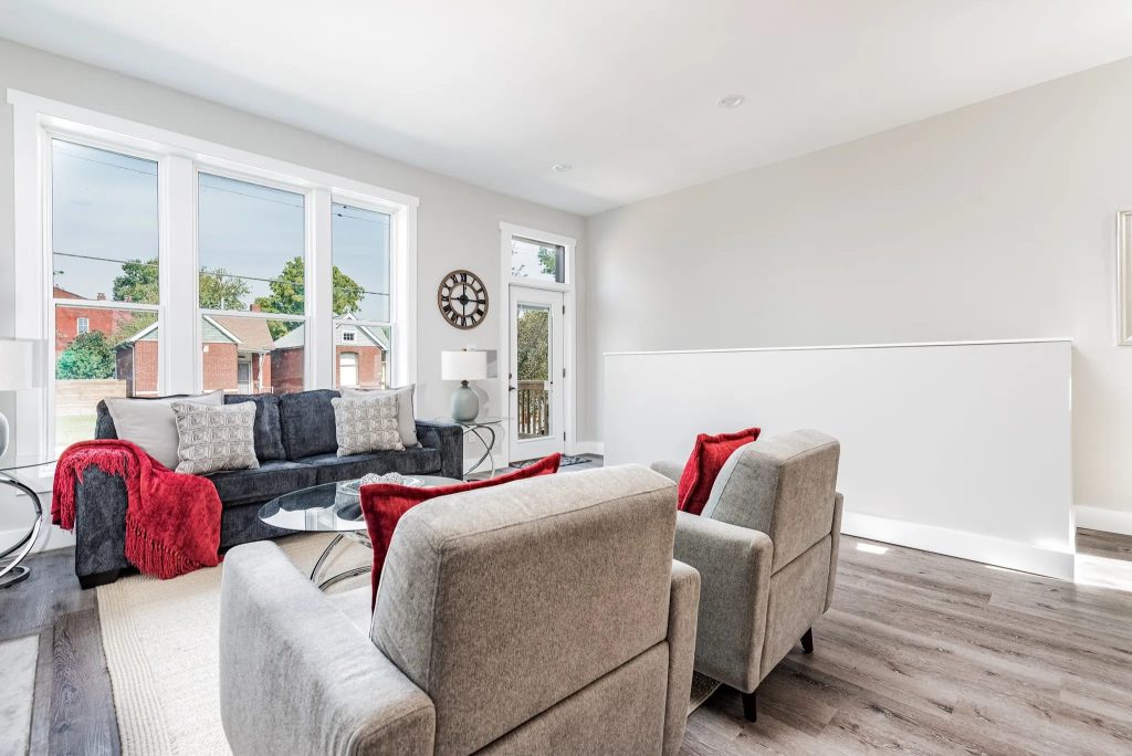 Open living area with vaulted ceiling and stair rail