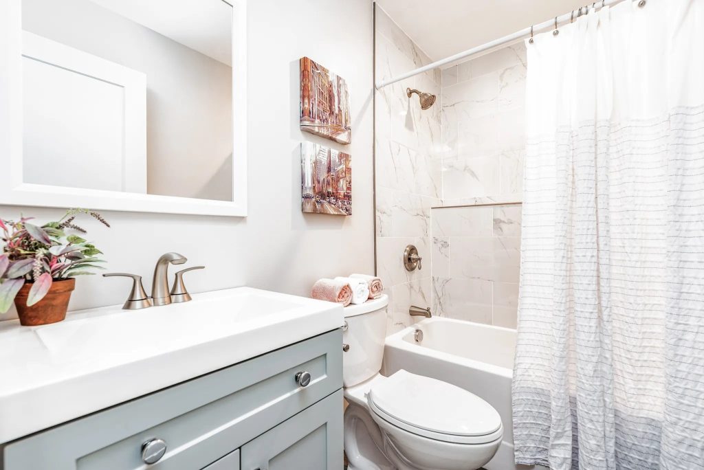 Bathroom with gray vanity and tiled tub surround