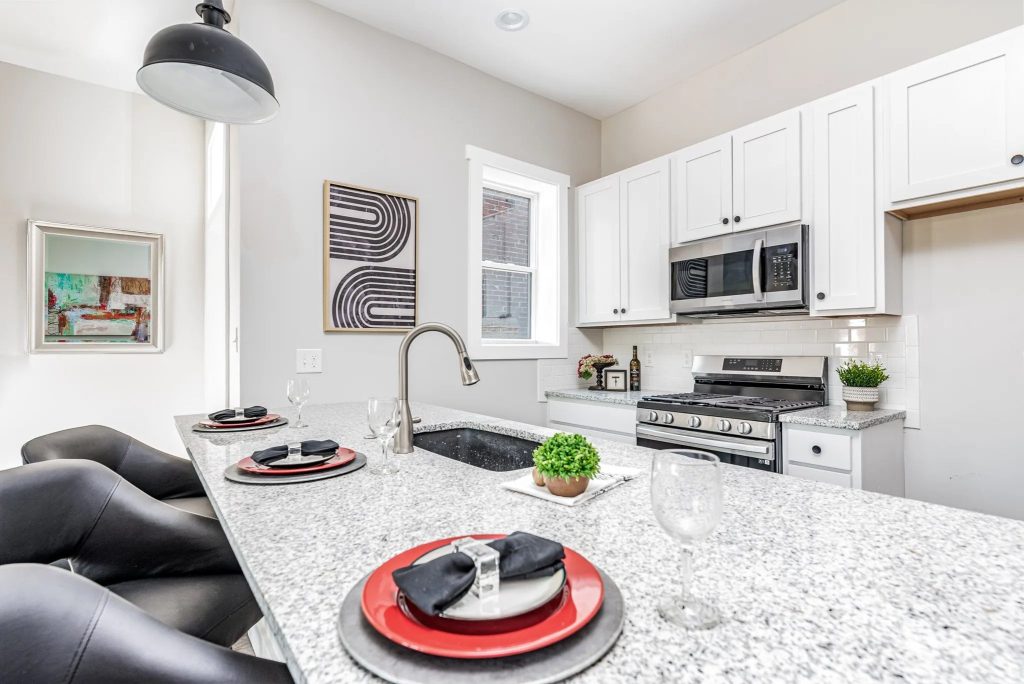 Kitchen island laid for dinner with stainless appliances