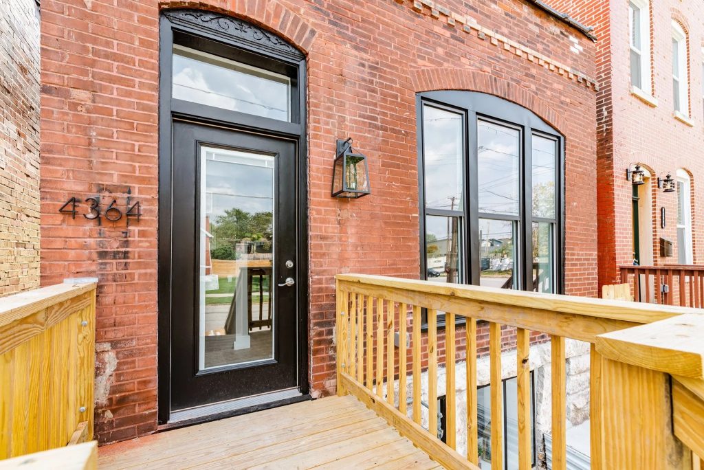 Brick house entrance with arched windows and new deck