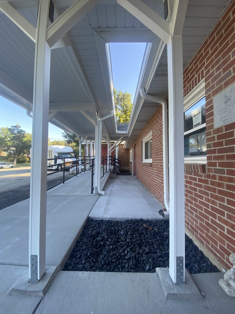 Covered walkway with gravel bed and white columns