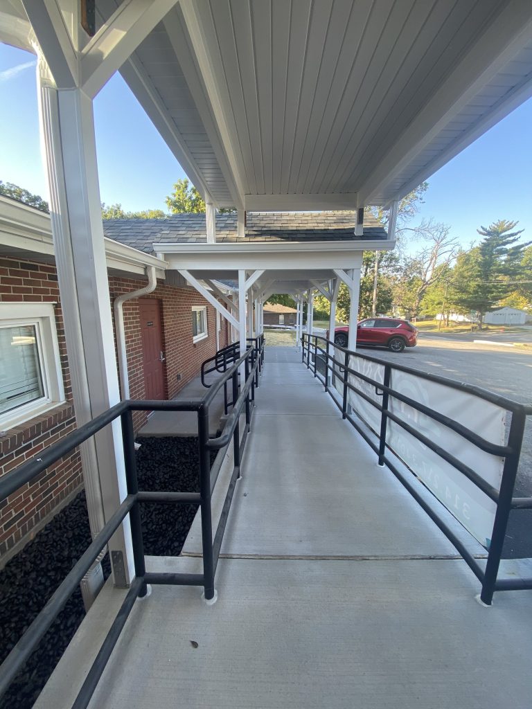 Accessible ramp with metal handrails under the new canopy