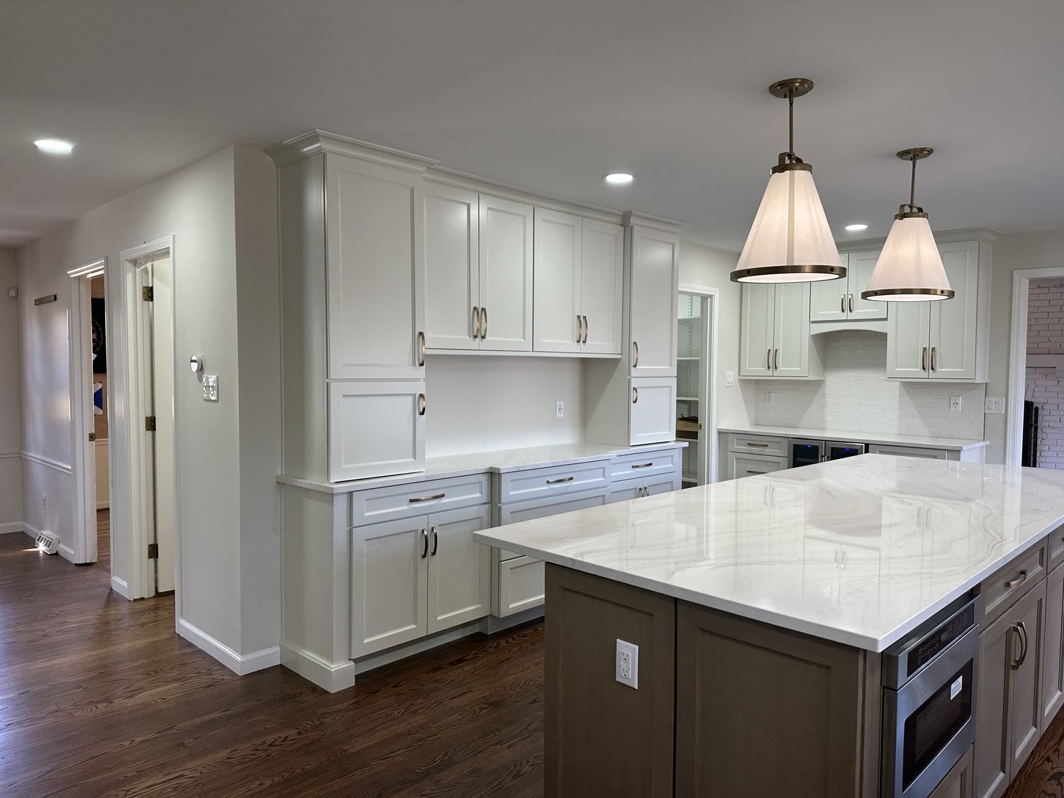 Renovated kitchen with white cabinetry and a marble island