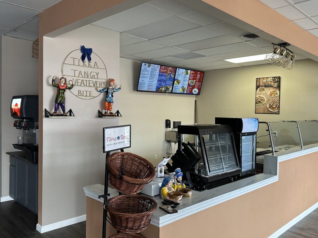 Restaurant service counter with menu screens and display fridge