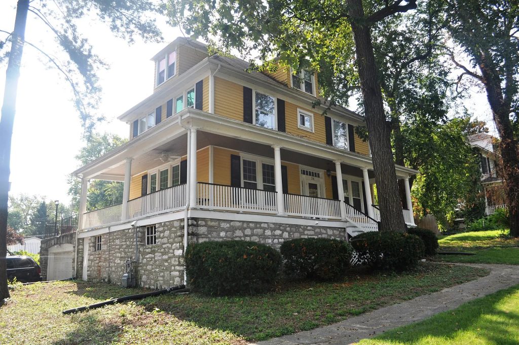 The original yellow clapboard house seen from the street