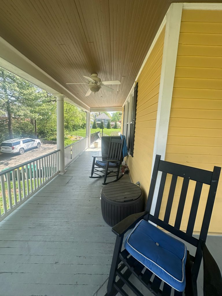 The original front porch with rocking chairs and painted wood decking