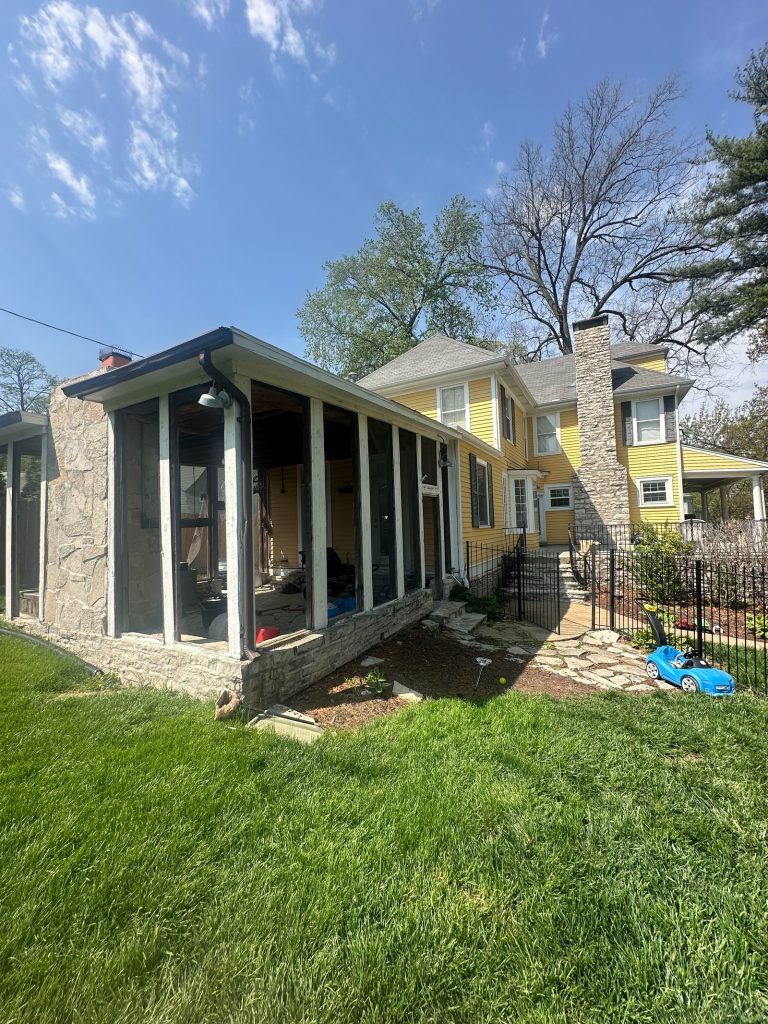 Original screened porch at the rear, set on a stone base