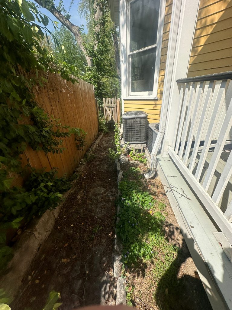 Narrow side yard with the original stone retaining wall