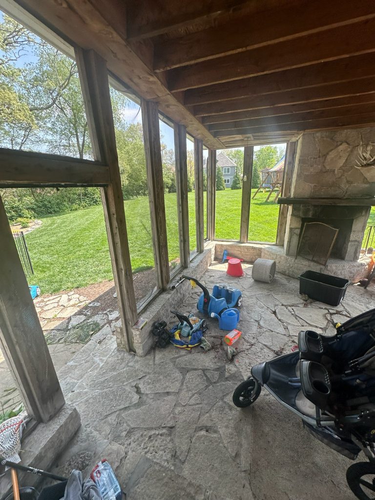 Inside the original screened porch, with a stone floor and stone fireplace