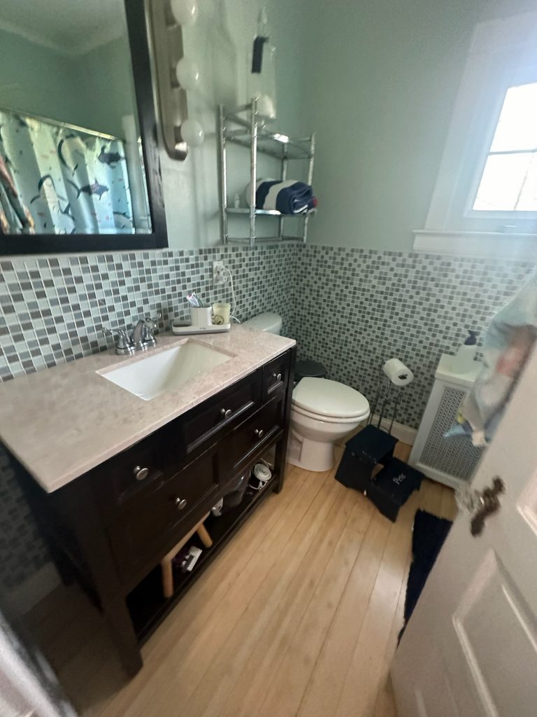Original bathroom with a dark vanity and mosaic tiled wall