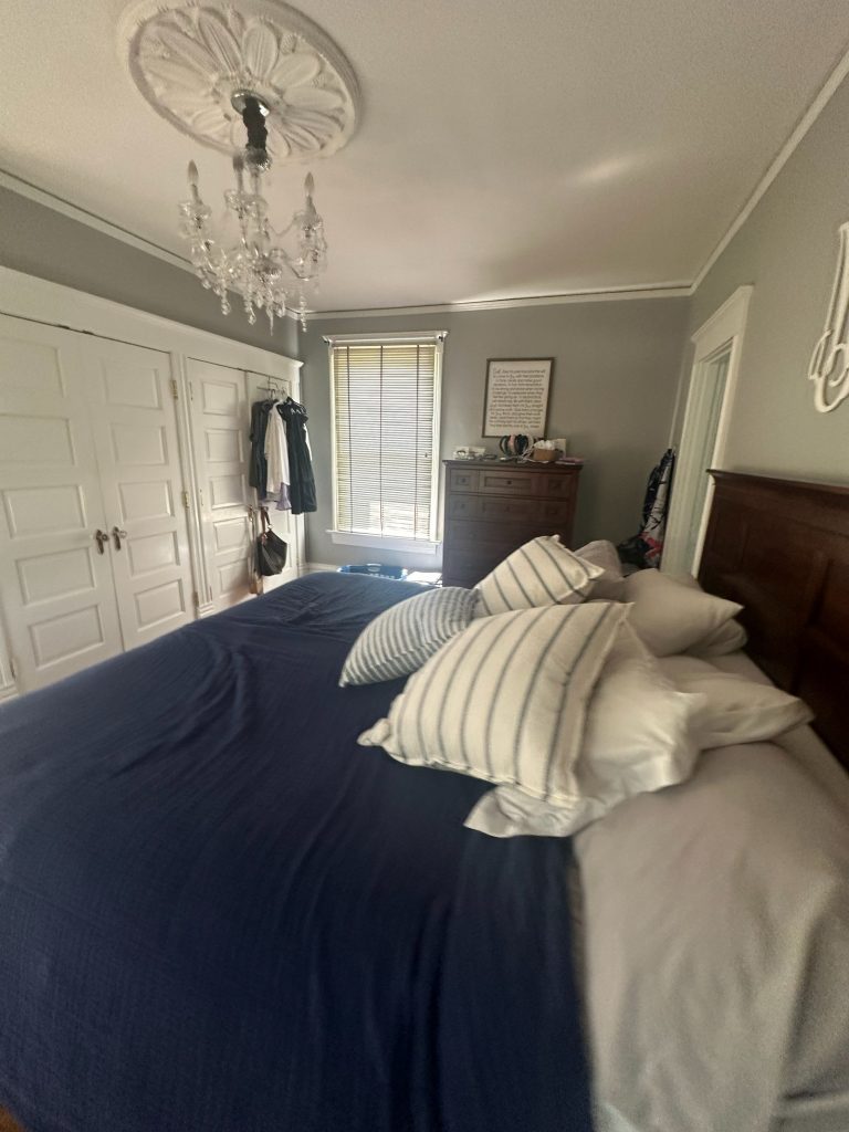 Original bedroom with a dark wood bed and chandelier
