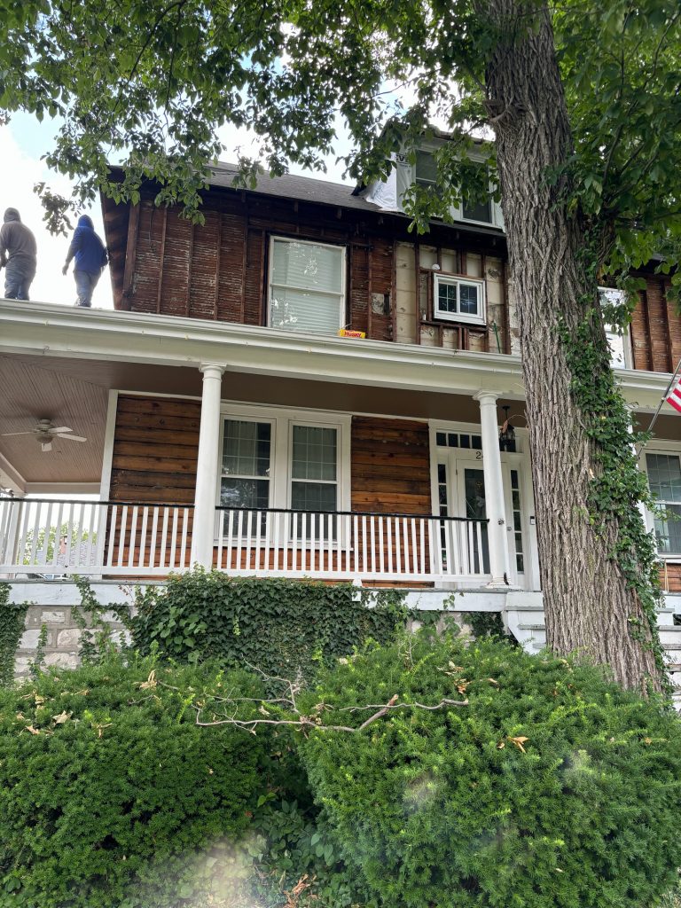 The original house with its siding removed at the front porch