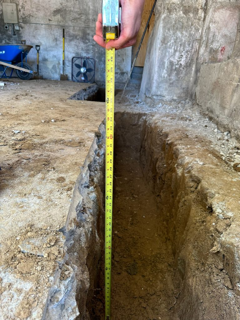 Tape measure showing the depth of the underpinning excavation