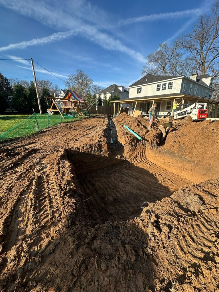 Trench cut across the yard for new services