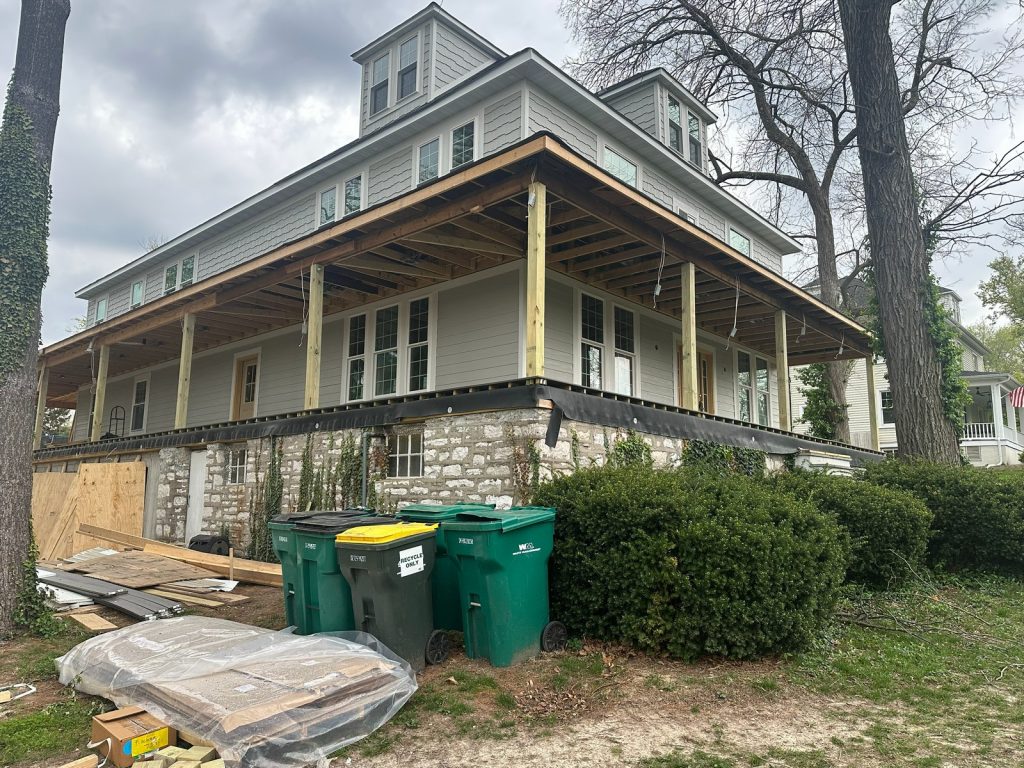 The original house on temporary posts with new siding started