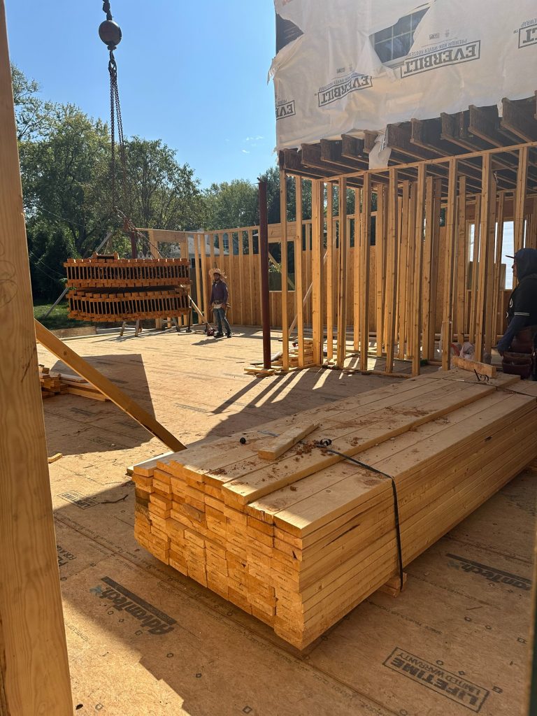 Framing underway on the new addition, with lumber staged on the deck