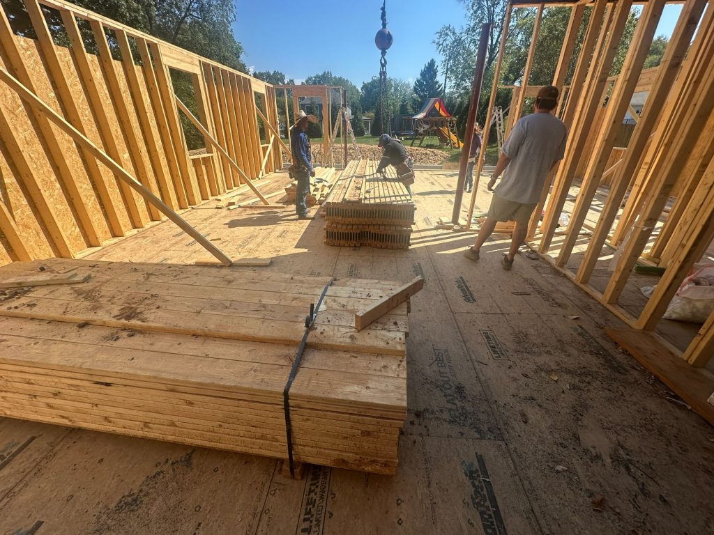 Carpenters raising framed walls on the new addition