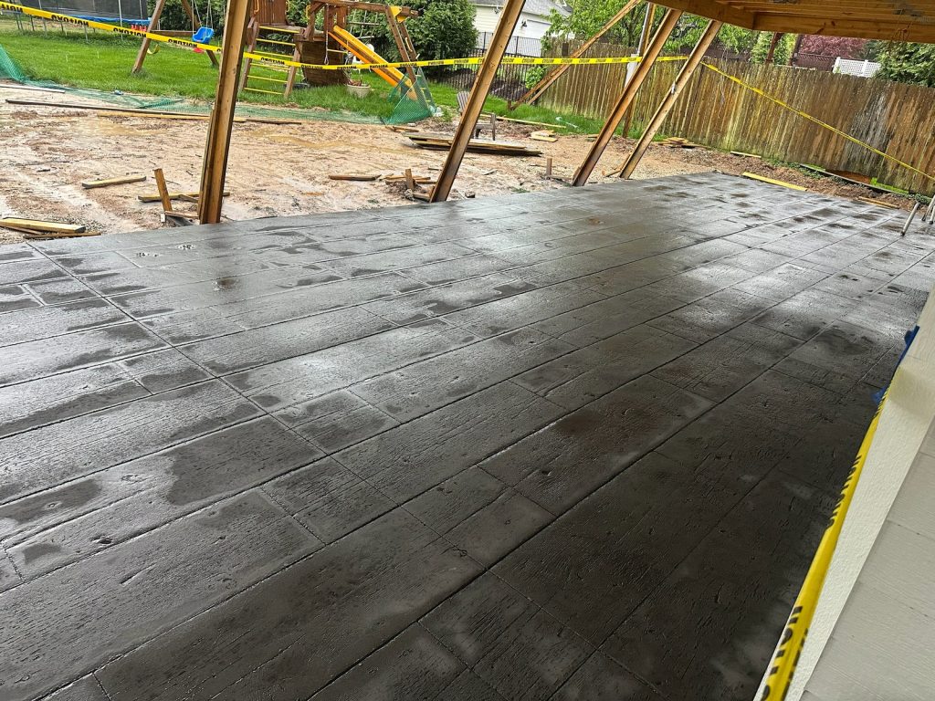 Freshly placed concrete slab beneath the new framing