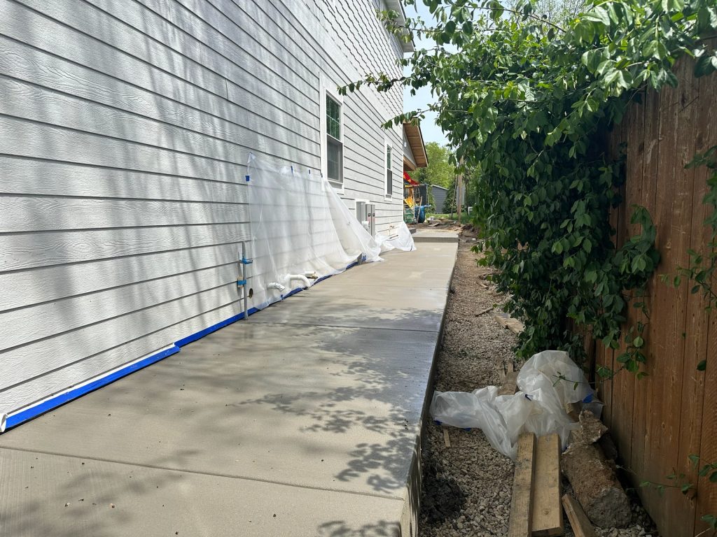 New lap siding and concrete path along the side of the house